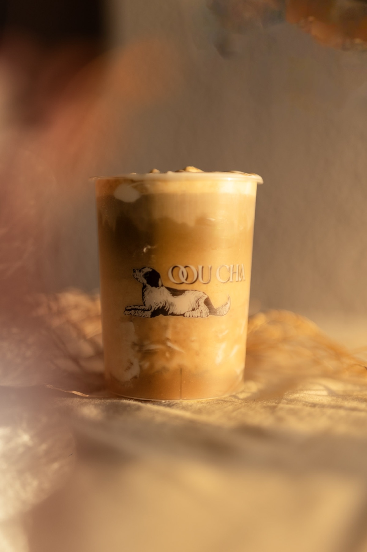 An Oou Cha tea latte with the café's dog illustration on the cup
