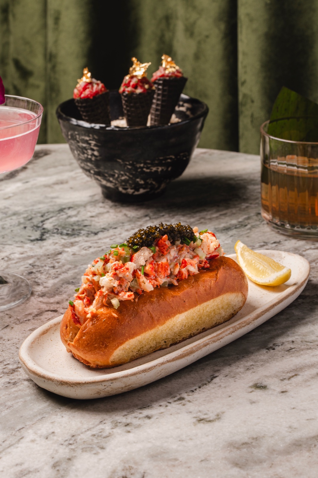 Lobster roll crowned with caviar on marble