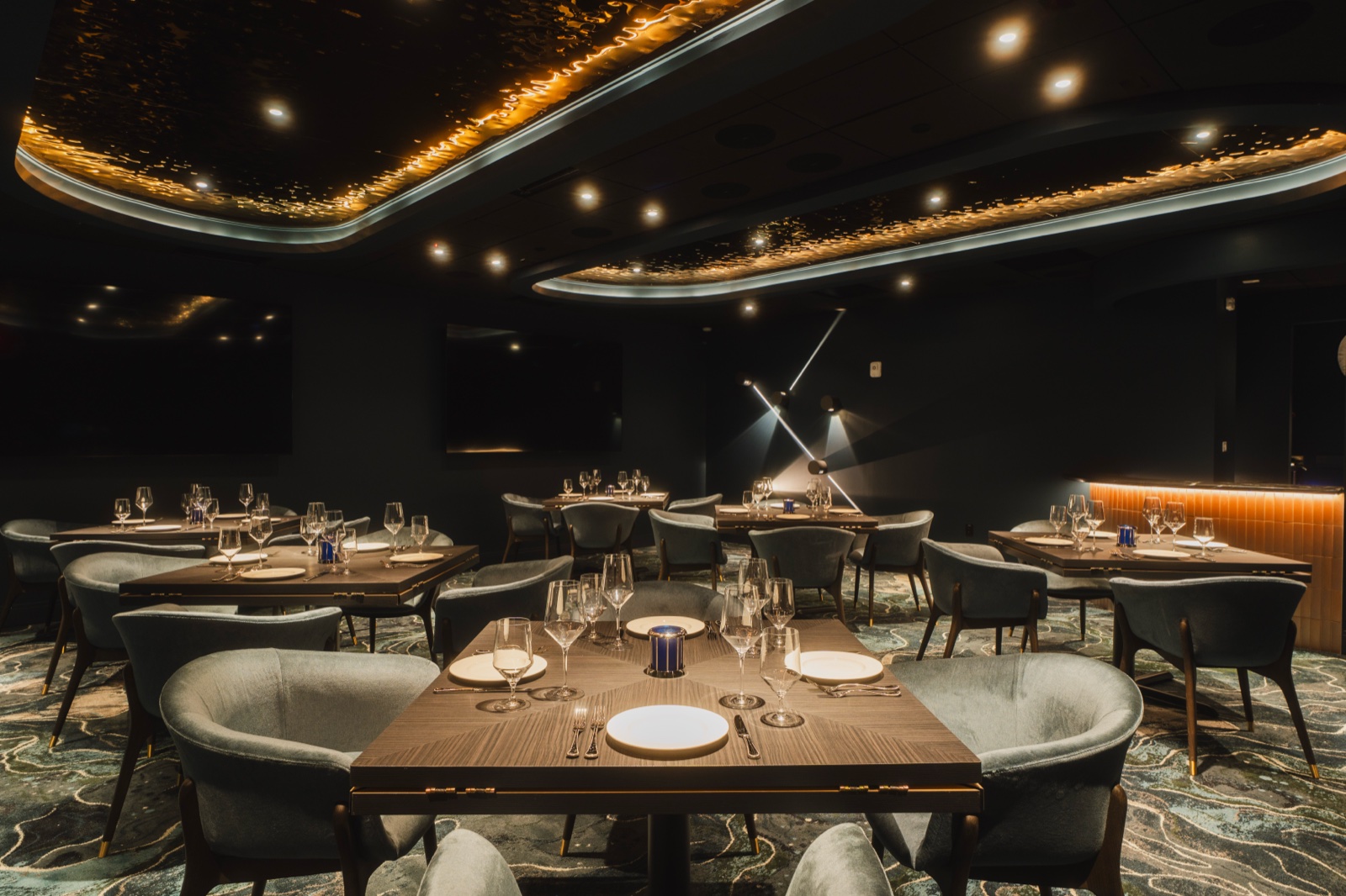 Dark dining room beneath a backlit ceiling cove