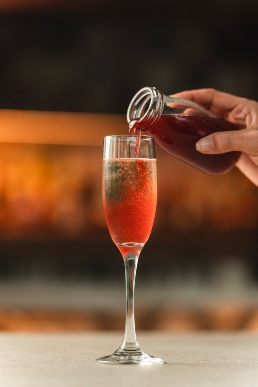 Red syrup poured into a sparkling flute