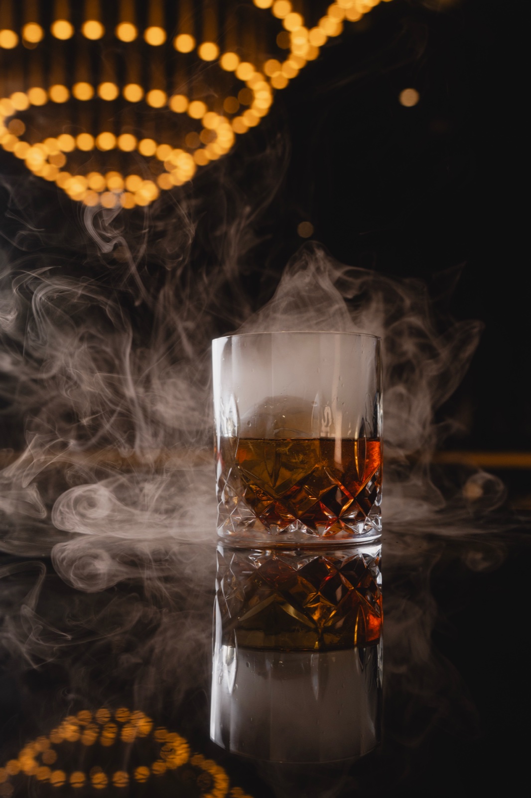 Smoky whiskey glass under soft bokeh