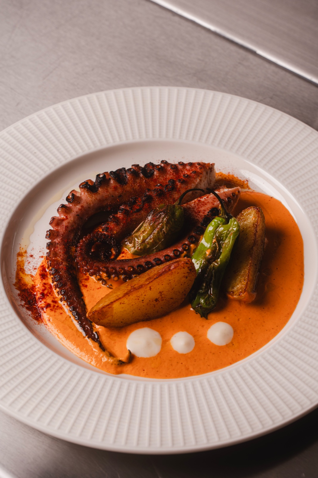 Charred octopus over red sauce with fingerling potatoes