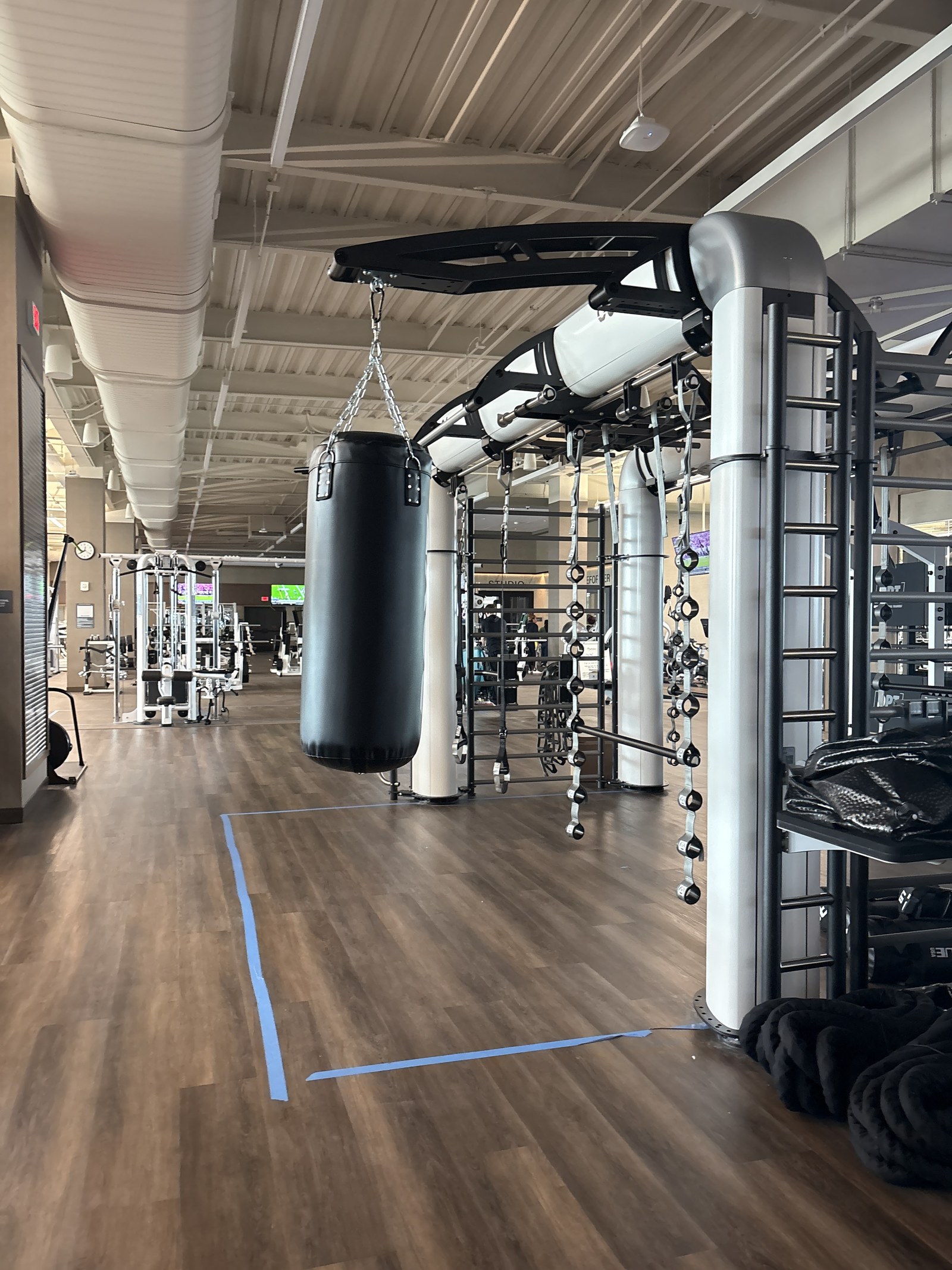 A functional training rig with a heavy bag and climbing bars.