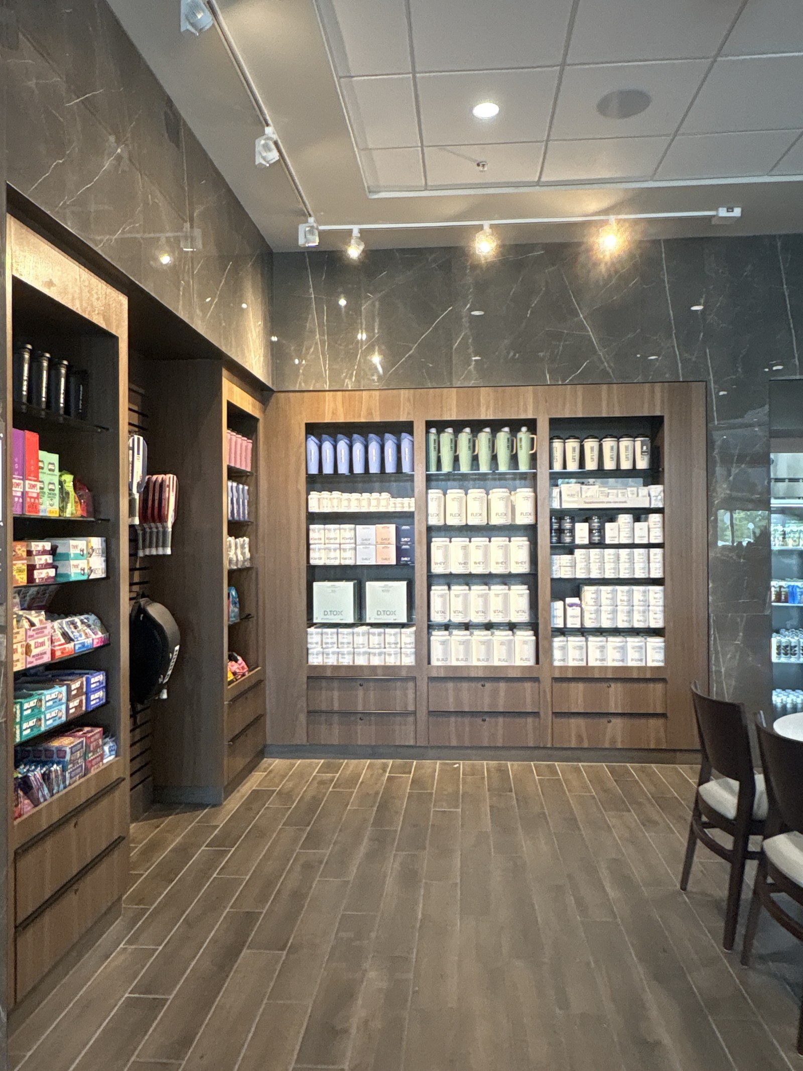 Wood shelving stocked with supplements, snacks and drinks.