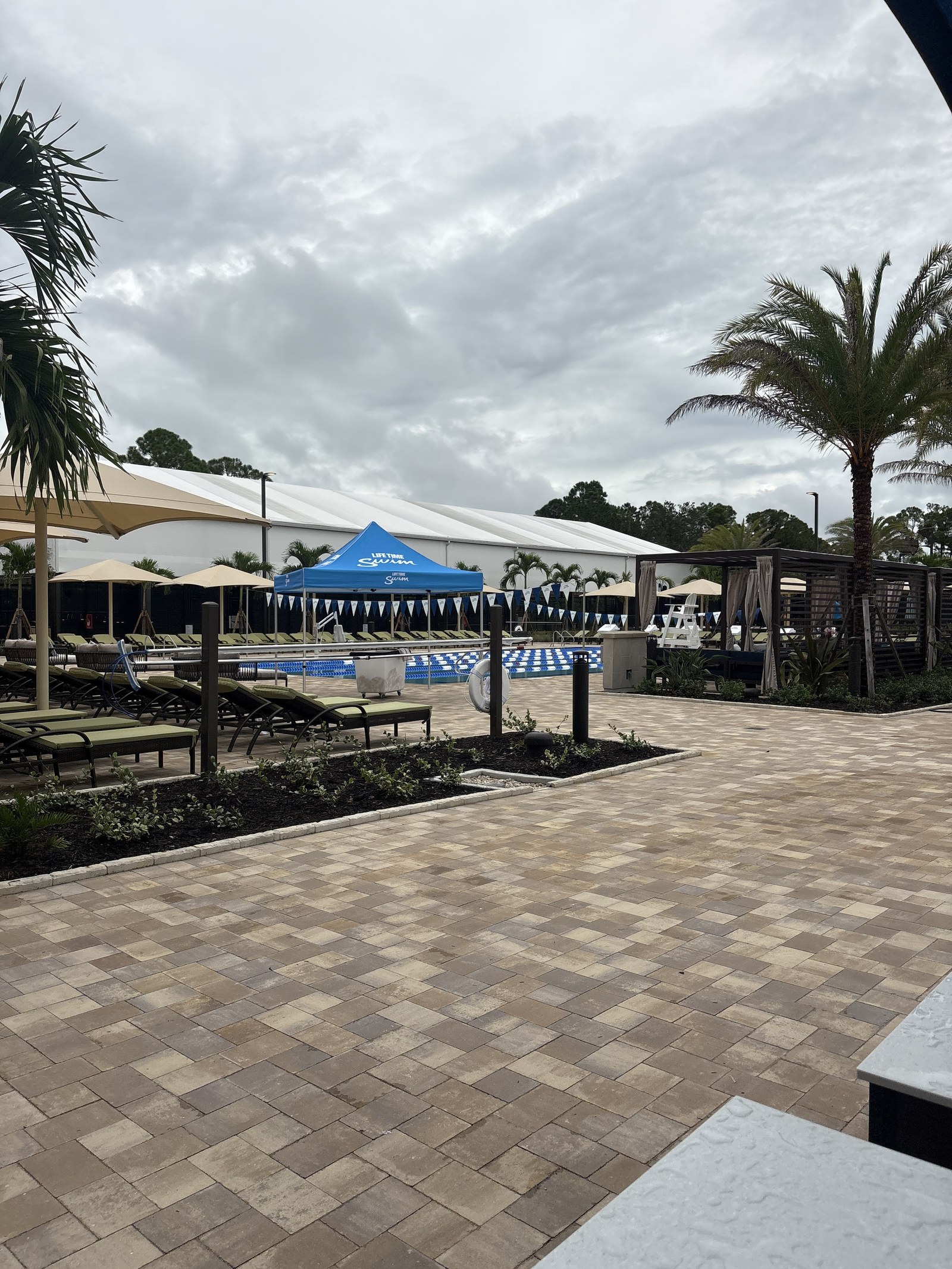 A paver walkway leading to cabanas and the pool deck.