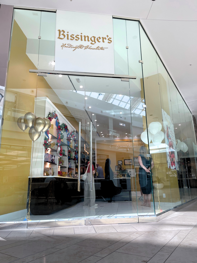 The glass storefront of the Bissinger's boutique, decorated with balloons, on the main level of the mall.
